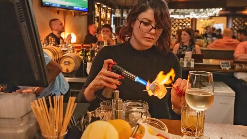 Bar tender toasting marshmallow with tourch