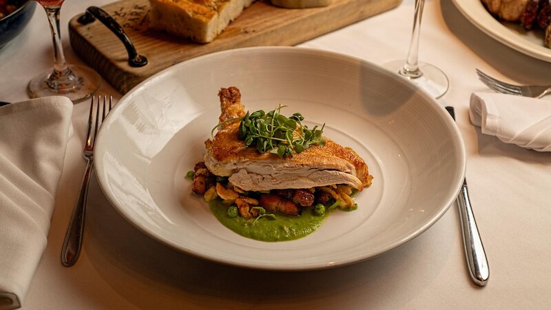 Chicken entree on a bed of peas and walnuts