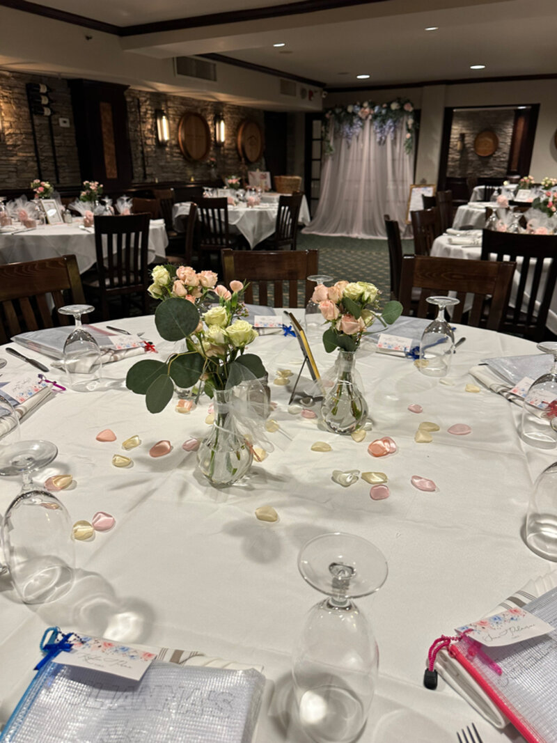 Private party table with white table cloth, flower center piece and flower petal decorations